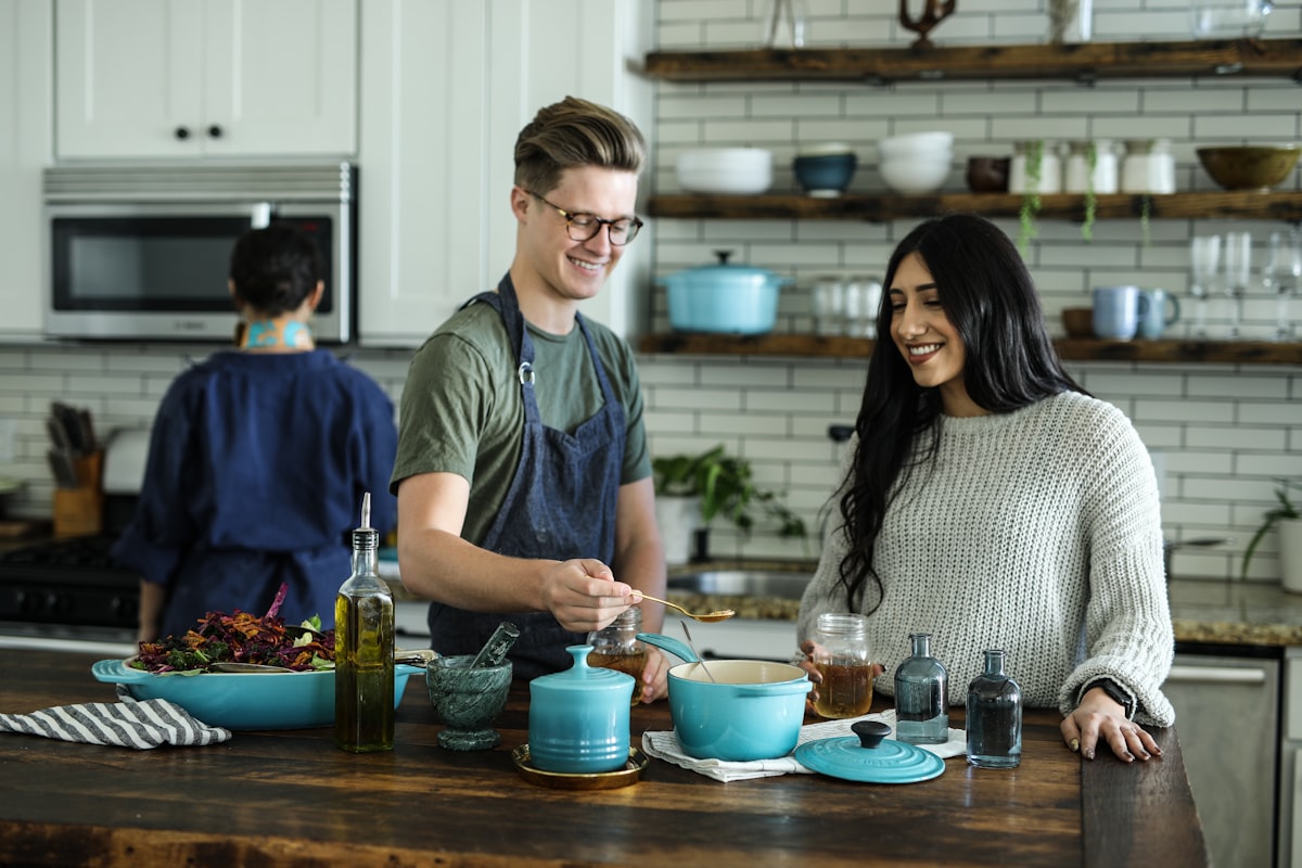Hosts preparing food together in a kitchen